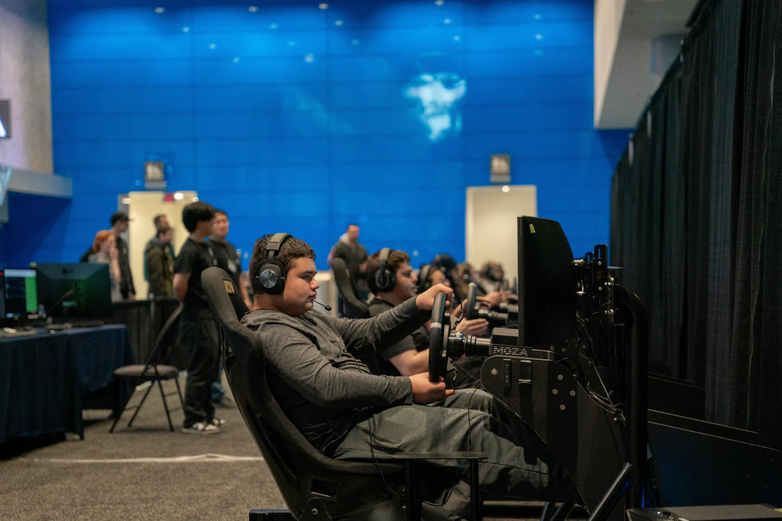 A guest driving an Axon simulator on the show floor at the Vancouver Auto Show